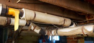 basement pipes wrapped in asbestos insulation