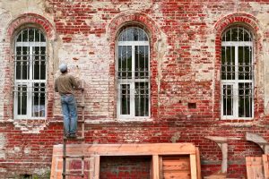 Man working on the side of a brick building