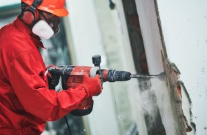 Worker Demolishing a Wall With a Jackhammer