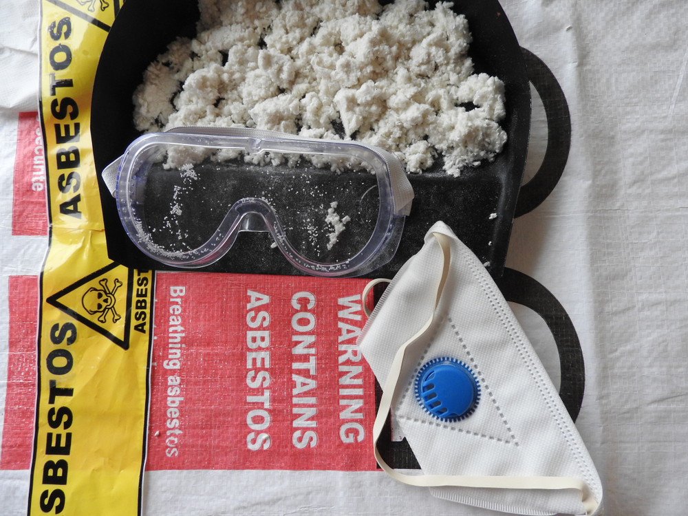 Asbestos with warning signs, breathing masks, and goggles