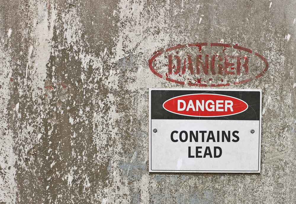 Red, black, and white sign with lead warning