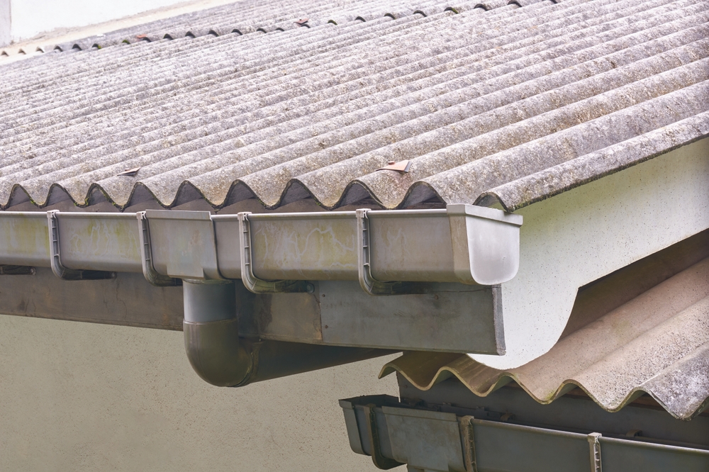 Section of corrugated asbestos cement roof with attached plastic gutters