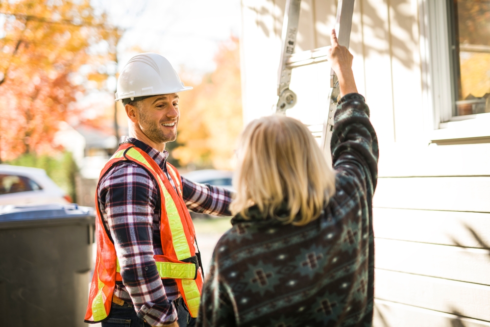 A man with a hard hat talking with a customer
