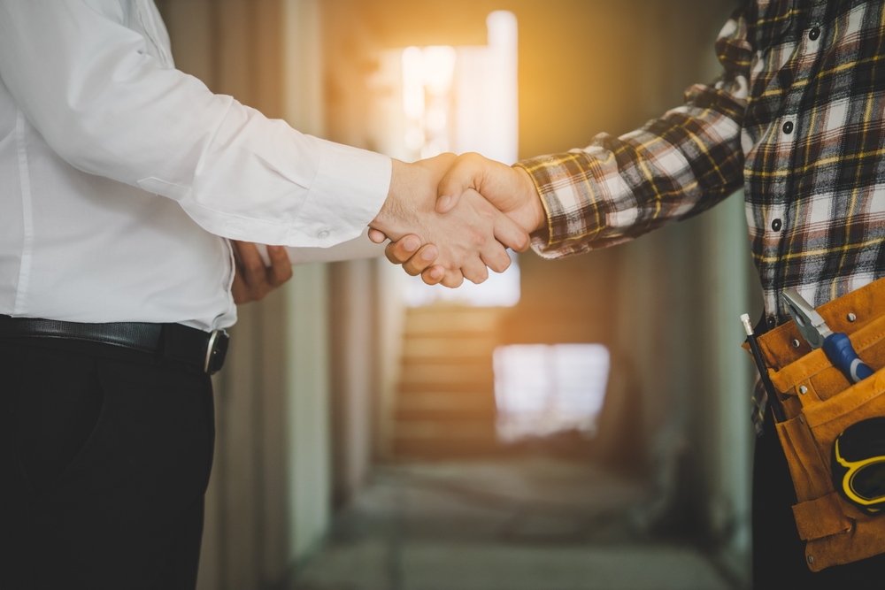 Client shaking hands with team builder at renovation site